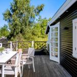 Deck with table, chairs, and view into green surroundings.