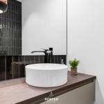 Waschbecken mit schwarzer Wand und Holzoberfläche