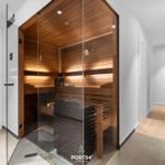 Sauna mit Holzwand und Glasfront in moderner Umgebung