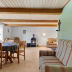 Living and dining area with fireplace, sofa, and wooden table.