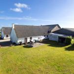 House with garden, terrace, and umbrella. Outbuildings and green surroundings.