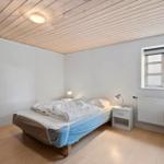 Bedroom with bed, nightstand, and window. Wooden ceiling and floor.