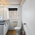 Bathroom with toilet, sink, and window