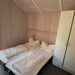 Zwei Einzelbetten, Kleiderschrank und Fenster mit Blick auf die Terrasse.