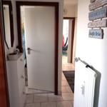 Eingangsbereich mit Spiegel, Schrank und Tür zu Wohnbereich.