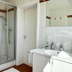 Badezimmer mit Dusche, Waschbecken und Spiegel