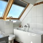 Badezimmer mit Dachfenster, Badewanne und Toilette