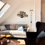 Wohnzimmer mit Sofa, Sessel und Dachfenster. Wanddekoration mit Fischen.