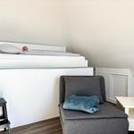 Schlafzimmer mit Hochbett, Sessel und Nachttisch