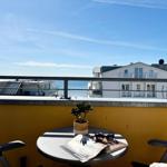 Terrasse mit Tisch, Stuhl und Blick auf das Meer und Gebäude.