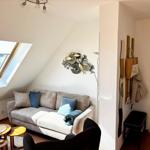 Wohnbereich mit Sofa, Sitzgelegenheit und Dachfenster. Wanddekoration und Hängeregale.