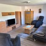 Wohnzimmer mit Sofa, Fernseher und Holzmöbeln.