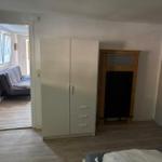 Schlafzimmer mit Kleiderschrank und Kamin, Blick in Wohnbereich mit Sofa.