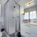 Helles Duschbad mit Badschrank und Föhn