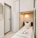 Schlafzimmer mit Bett, Schrank und Spiegel an der Wand.