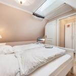 Bedroom with double bed, window, and door to bathroom.