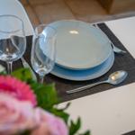 Table set with plates, glasses, and cutlery on placemat.