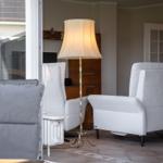 A living room with gray chairs, a floor lamp, and a wooden cabinet.
