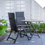 Outdoor area with table and two chairs in front of white wood paneling.