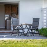 Terrace with table and two chairs. Kitchen visible in the background.