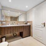 Bathroom with sink, mirror, toilet, and window.