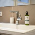 Sink with modern faucet and soap bottle.
