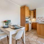 Dining area with table and chairs. Kitchen area with wooden cabinets and countertop.