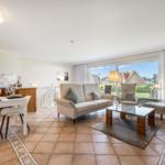 Living and dining area with sofa, table, and view of the surroundings.