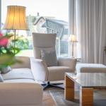 Living room with seating area, glass table, and garden view