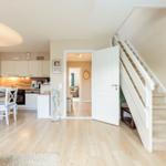 Wohnung mit Essbereich, Küche und Treppe zur oberen Etage.