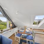 Dachgeschosses mit Tisch, Stühlen und Blick auf Garten