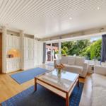 Wohnzimmer mit Sofa, Glas-Tisch und Blick auf Garten