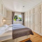 Schlafzimmer mit Bett, Kleiderschrank und Fenster zum Balkon.