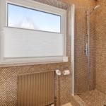 Bad mit Dusche und Fenster mit Jalousie