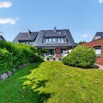 Haus mit Garten, Terrasse und Grillplatz. Roter Backsteinbau mit Dachgauben.