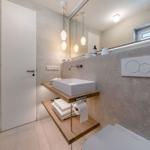 Moderne Badewanne mit Waschbecken, Spiegel und Fenster.