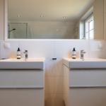 Zwei Waschbecken mit Spiegeln und Duschbereich im Badezimmer.