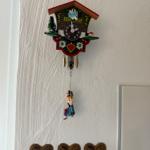 Ein deutscher Kuckucksuhr mit Figur hängt an einer Wand.