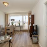Wohnung mit Essbereich, Schlafzimmer und Balkon. Holzboden und moderne Einrichtung.