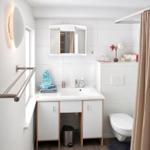 Badezimmer mit Waschbecken, Spiegelschrank, Toilette und Duschvorhang.