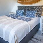Schlafzimmer mit Bett, Kopfteil und Wanddekoration.