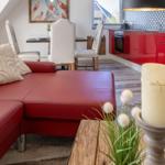 Roter Ledersofa im Wohnbereich mit Essbereich und roter Küche.