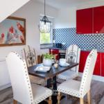 Esszimmer mit roter Küche und Tisch mit Stühlen