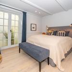Schlafzimmer mit Bett, Fenster und Holzboden.