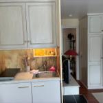 Küche mit Unterschrank, Spüle und Hängeschränken. Im Hintergrund steht ein Kleiderschrank.