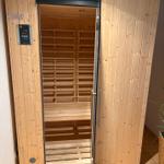 Sauna mit Holzverkleidung und Bedienfeld an der Tür
