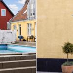 Pool area with terrace and outdoor shower near yellow house