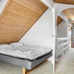 Schlafzimmer mit Dachschrägen, Bett und Blick in Flur