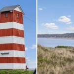 Roter Leuchtturm mit weißen Streifen und Blick auf die Küste mit Dünen.