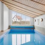 Innenpool mit großem Fenster und Holzdecke. Fußball im Wasser.